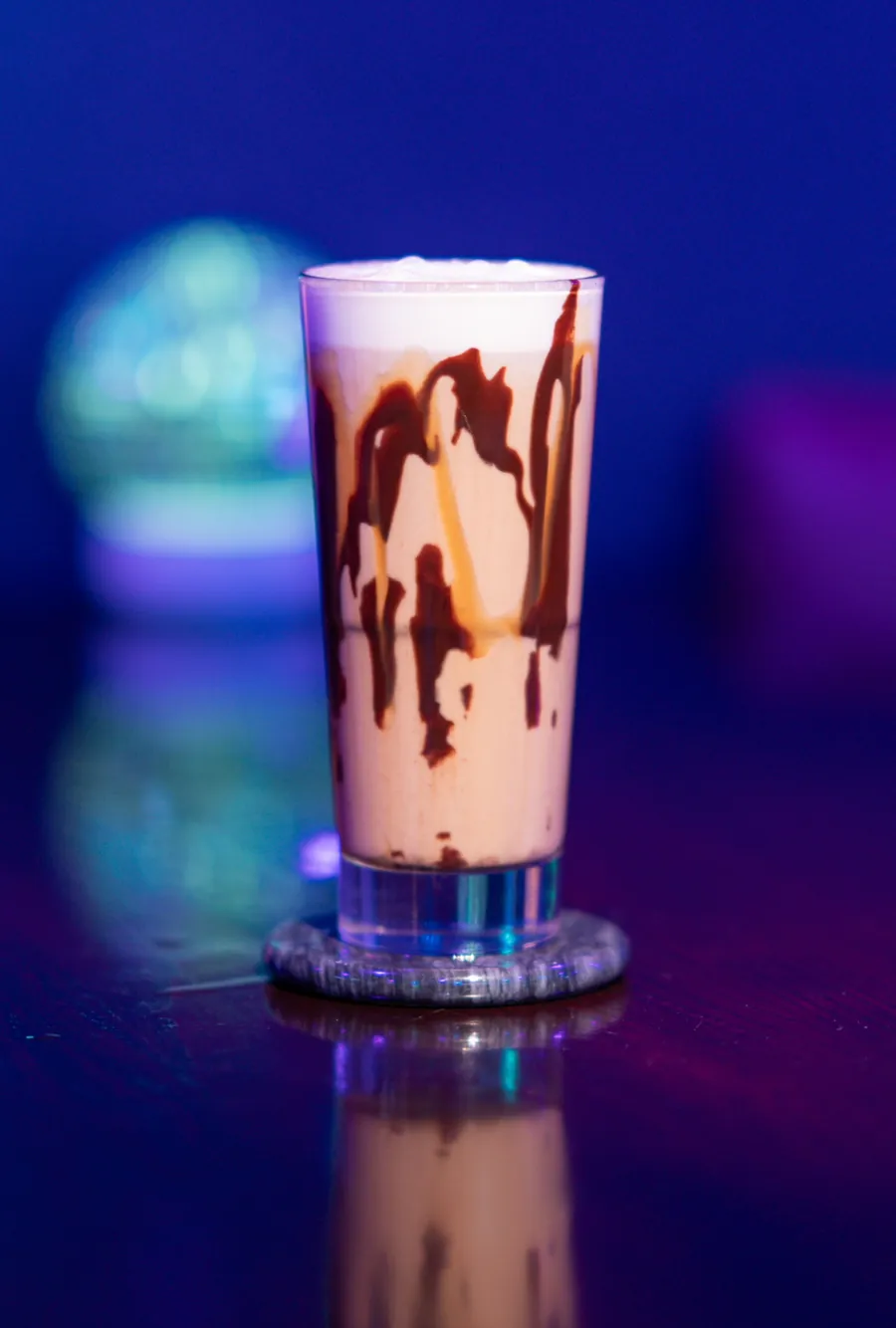 Iced coffee with chocolate and caramel drizzle and cold foam at Decades Kava in Longwood, FL