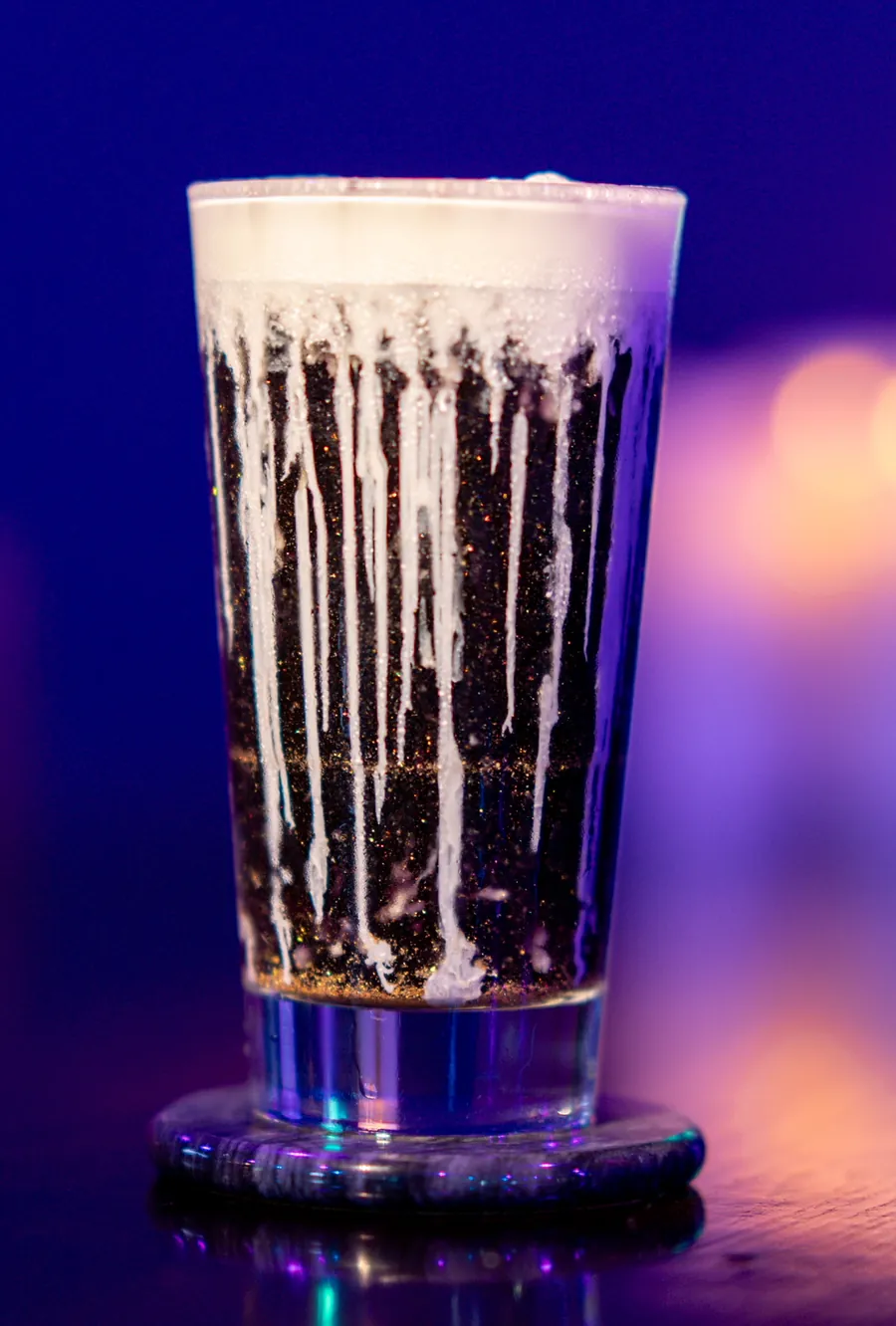 Dark iced coffee drink with white drizzle and foam at Decades Kava in Longwood, FL